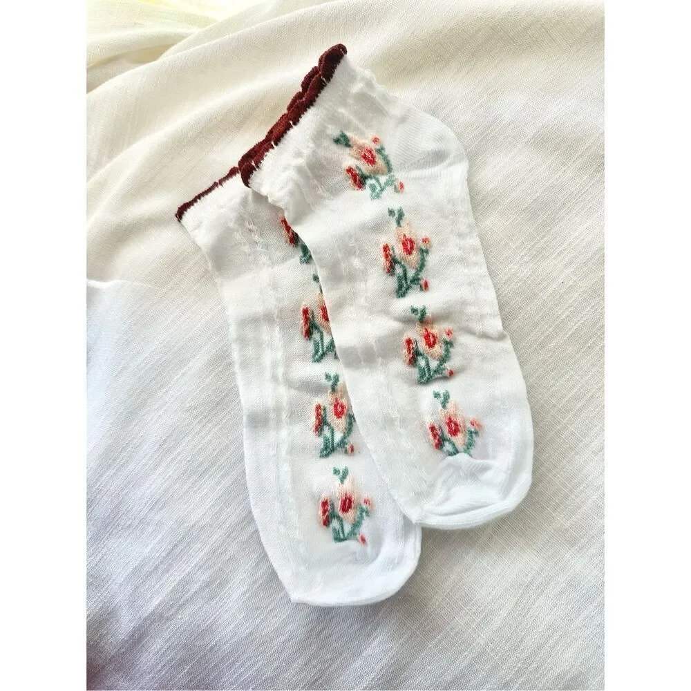 Green, burgundy, pink, and red floral white socks