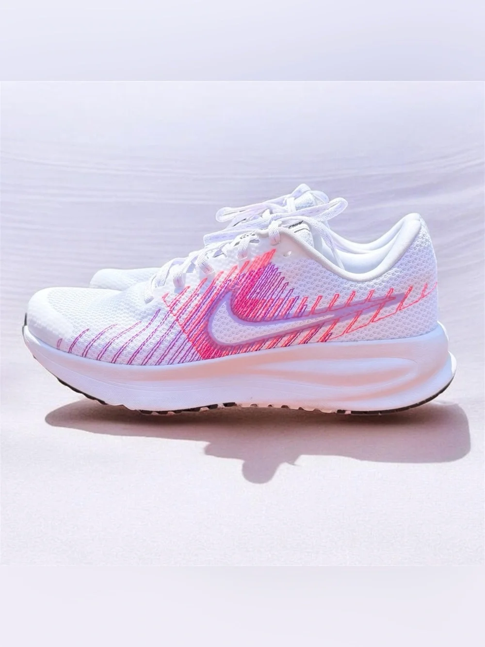 Nike Women's Run Defy running shoes, featuring a white mesh upper